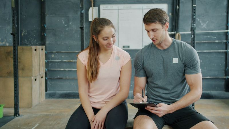A personal trainer going through a workout plan with a client